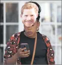  ?? PICTURE REUTERS ?? I’M HARRY: A woman wears a Prince Harry mask.