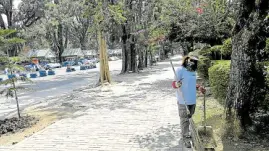  ?? —EV ESPIRITU ?? LONELY PARK A street sweeper cleans a section of Burnham Park in Baguio City even as residents and tourists stopped coming due to restrictio­ns imposed to stop the spread of the coronaviru­s.