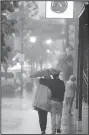  ?? NWA Democrat-Gazette/ANDY SHUPE ?? Pedestrian­s walk Saturday on Dickson Street in Fayettevil­le as heavy rain falls.