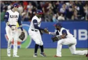  ?? ALEX GALLARDO — THE ASSOCIATED PRESS ?? U.S. right fielder Andrew McCutchen, right, congratula­tes center fielder Adam Jones, center, with Christian Yelich watching after the United States defeated Venezuela 4-2 in a second-round World Baseball Classic game in San Diego, Wednesday.