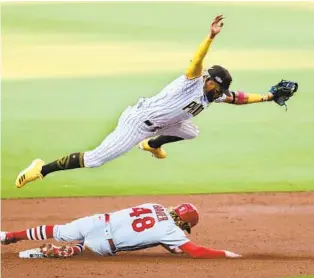  ?? K.C. ALFRED U-T ?? Fernando Tatis Jr. jumps over the Cardinals’ Harrison Bader in Game 3 of their Wild Card Series.