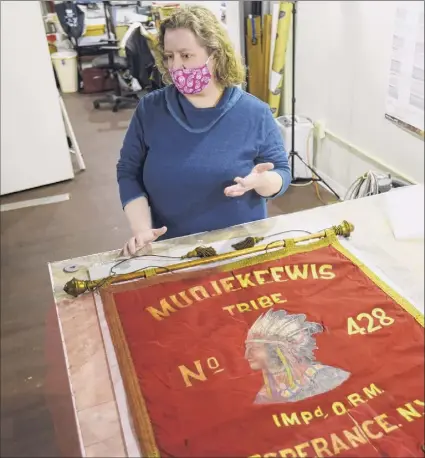  ?? Paul Buckowski / Times Union ?? Sarah Stevens, owner of Zephyr Preservati­on Studio in Cohoes, talks about her work to preserve a banner made of silk fabric. The banner is part of the collection of the Esperance Historical Society.