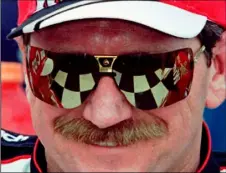  ?? AP Photo/Terry Renna ?? In this 1997 file photo, the checkered flag in Victory Lane reflects in the sunglasses of Dale Earnhardt,, after he won his eighth consecutiv­e 125-mile qualifying auto race for the Daytona 500 at Daytona Internatio­nal Speedway in Daytona Beach, Fla.