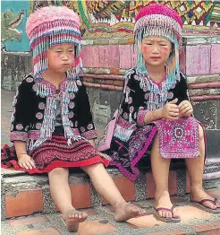  ??  ?? Two more of a group of girls in traditiona­l costume at the temple