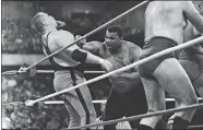  ?? CHARLIE BENNETT/AP FILE PHOTO ?? The Chicago Bears’ William Perry, center, lands a punch on pro wrestler Jim “The Anvil” Neidhart on April 7, 1986, during Wrestleman­ia 2 in Rosemont, Ill. Neidhart, 63, died Monday after the Pasco Sheriff’s Office said he fell at home, hit his head and “succumbed to his injury.”