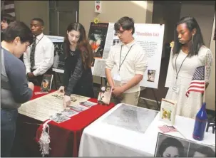  ?? The Sentinel-Record/Richard Rasmussen ?? WE THE PEOPLE: Crystal Lambert, left, listens to Malvern Middle School student Veronika Jergenson discuss her book as fellow classmates Jeremy Beck and Leona Hogan, right, listen during the “We the People: Our Stories” exhibit at National Park College...