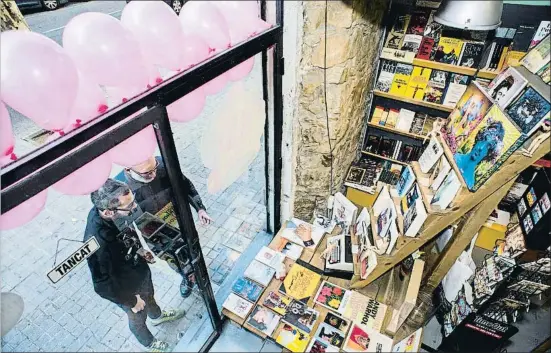  ?? XAVIER CERVERA ?? Josep Vitas, propietari de la llibreria Antinous, observa els preparatiu­s del Pink Friday amb Daniel Fernández, d’Acegal