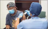  ?? Henry Ford Health System / AFP via Getty Images ?? A volunteer receives Moderna Therapeuti­cs’ vaccine candidate to fight COVID-19 in August in Detroit.