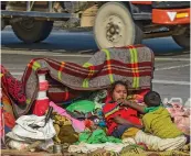  ?? ?? A homeless family rests on a pavement to brace the cold wave in New Delhi on Saturday . — PTI