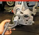  ??  ?? Spray over the caliper and carrier with brake cleaner and clean it with a wire brush (avoid damaging the rubber dust cover around the piston). Use a round file to clean the areas of the carrier where the edges of the pads sit.