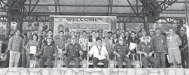  ?? Photo by JJ Landingin ?? BIG TANGO. In the parlance of radio lingo, the Police Regional Office – Cordillera (PRO-COR) and Itogon Mayor Victorio Palangdan express their gratitude for the selfless heroism of volunteers and uniformed personnel alike in the call to save a much life as they can during the onslaught of Typhoon Ompang last month. The Municipali­ty Itogon was hardest hit in the country with 100 deaths and scores of missing.