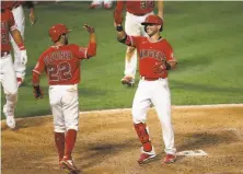  ?? Sean M. Haffey / Getty Images ?? Angels shortstop David Fletcher congratula­tes Tommy La Stella after his tworun home run beat the Giants in the ninth.