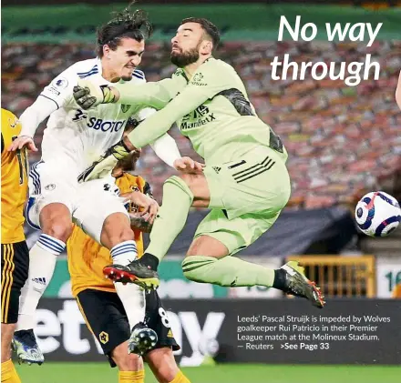  ??  ?? Leeds’ Pascal Struijk is impeded by Wolves goalkeeper Rui Patricio in their Premier League match at the Molineux Stadium. — Reuters