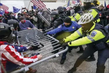  ?? JOHN MINCHILLO — THE ASSOCIATED PRESS FILE ?? Rioters try to break through a police barrier at the Capitol in Washington, on Jan. 6, 2021. Egged on by soon-to-be former President Donald Trump, a crowd of demonstrat­ors demanded that the electoral vote counting be stopped.