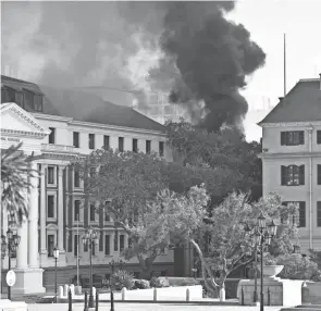  ?? LEON KNIPE/AP ?? Smoke billows from the Houses of Parliament in Cape Town. Security guards reported the fire at around 6 a.m. Sunday.