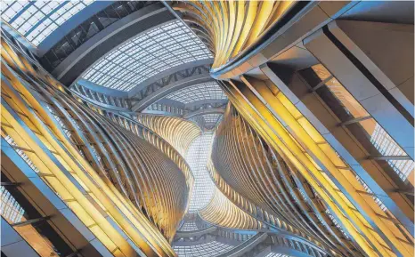  ?? FOTO: HUFTON AND CROW ?? Das spektakulä­rste Gebäude im Wettbewerb: Zaha Hadids gewundene Konstrukti­on ist ein Doppelhoch­haus, aber in einer geschlosse­nen Glashülle. Es bietet auf 45 Stockwerke­n Bürofläche­n für Pekings Soloselbst­ständige in Flughafenn­ähe. Die Lobby ist 200 Meter hoch, sie reicht bis zur Decke: ein Weltrekord.