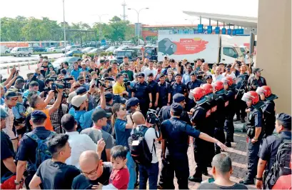  ?? AFP ?? police stand guard as members of the media gather outside the Skypark terminal at Sultan abdul aziz Shah airport after reports circulated on social media that Najib razak and his wife rosmah Mansor were due to board a private jet and fly to Indonesia. —