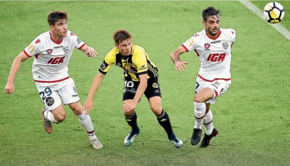  ??  ?? Phoenix midfielder Michael McGlinchey, middle, is outnumbere­d by the Adelaide defence.
