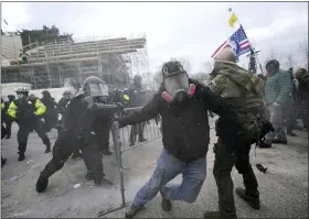  ?? JULIO CORTEZ — THE ASSOCIATED PRESS ?? Trump supporters try to break through a police barrier Wednesday at the U.S. Capitol in Washington.