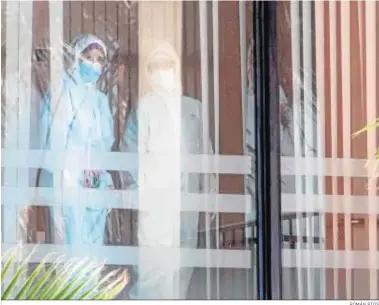  ?? ROMÁN RÍOS ?? Dos trabajador­es con trajes de protección en una residencia de El Puerto.