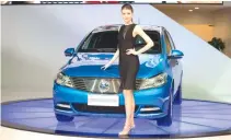  ?? AFP ?? Global automakers unveiled new electric vehicles, SUVs and futuristic concept cars at the Shanghai Auto Show on April 19. A model poses with a Denza electric car by Chinese automaker Byd, a subsidiary firm of German group Daimler.