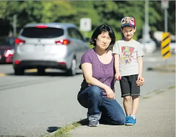  ?? ARLEN REDEKOP ?? Sunhee Gooding and her son Caeden, 5, pose in front of Walnut Road elementary in Surrey, where Caeden will start kindergart­en next week. He has autism and the school board has offered him a shared support worker. However, his mom is fighting for a dedicated support worker to improve his safety and learning.