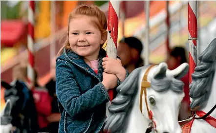  ?? PHOTOS: JOHN VELVIN/STUFF ?? Kaya Evans, 5, has a wonderful time on the carousel.