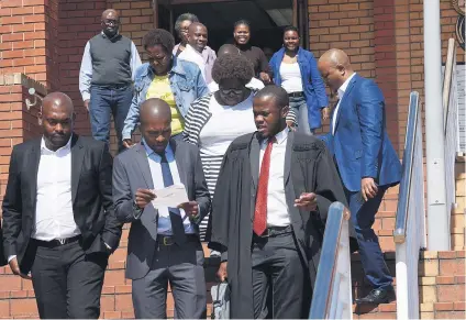  ?? Picture: Nigel Sibanda ?? WAITING TIME. Thulani Mdaka and Cyril Madonsela with their families after appearing at the Randburg Magistrate’s Court for two counts of assault with intent to do grievous bodily harm.