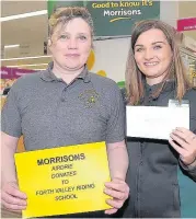  ?? 220218morr­isons_04 ?? Riding high Lorraine Hepburn of Riding for the Disabled Forth Group accepts a donation from Morrisons’ service manager Claire Norman