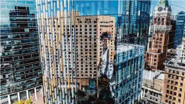  ?? Photos by Noah Berger/Special to the Chronicle ?? The Key Building at 1100 Broadway, center, reflects the scene around it in downtown Oakland. The building’s website describes the project as a modern tower “at the forefront of urban reinventio­n.”