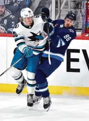  ?? Fred Greenslade/Associated Press ?? The Sharks’ Fabian Zetterlund checks the Jets’ Nate Schmidt on Monday in Winnipeg, Manitoba.