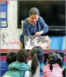  ??  ?? Nina Crews, illustrato­r of “A Girl Like Me,” reads to children at an early childhood education center.