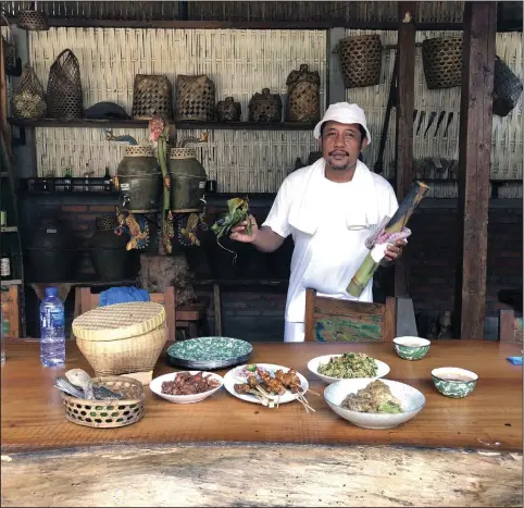  ?? (Patricia Tanumihard­ja) ?? Chef and village priest Jero Mangku Dalem Suci Gede Yudiawan at his restaurant, Dapur Bali Mula, in Bali, Indonesia in 2022. Chef Yudi, as he is affectiona­tely called, is holding a bamboo tube used to cook a tuna dish.