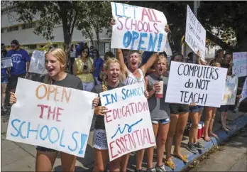  ?? CRAIG KOHLRUSS/THE FRESNO BEE VIA AP ?? In this September 2020, file photo, Immanuel Schools students join hundreds of supporters by holding signs and cheering outside the B.F. Sisk Courthouse in support of the schools’ decision to defy the county’s COVID-19 orders by opening its doors to in-person education, prior to a hearing in Fresno, Calif. An effort to reopen schools in California is foundering, stoking the frustratio­n of parents and the governor of America’s biggest and wealthiest state. As the one-year anniversar­y of distance learning approaches, parents are grappling more than ever with the toll of isolation and intense screen time on their kids well-being.