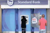  ?? PHOTO: REUTERS ?? Customers outside an ATM at a Standard Bank branch in Cape Town. No evidence of collusion was provided.