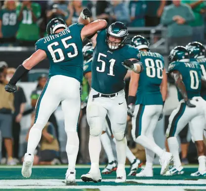  ?? TIM NWACHUKWU/GETTY ?? Eagles offensive lineman Lane Johnson (65) celebrates with Cam Jurgens after D’Andre Swift’s touchdown in the fourth quarter Thursday night against the Vikings.