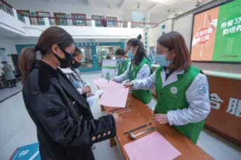  ??  ?? Hospital workers in Donglin, a town in Zhejiang Province, east China, give leaflets to visitors urging them to use severing chopsticks and spoons while eating in a group on March 17