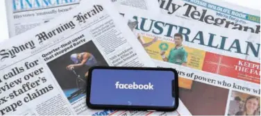  ?? Reuters ?? ↑
Photo shows a phone screen with the Facebook logo and Australian newspapers in Canberra on Thursday.