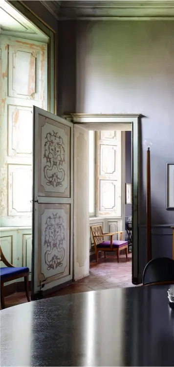  ??  ?? DANS LA SALLE À MANGER, une table ovale magistrale occupe l’espace. Les teintes des murs répondent aux fresques d’origine des portes. Verres (Hermès).