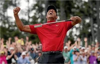  ?? AP ?? Tiger Woods celebrates after sinking his putt to win on the 18th green during the final round of the Masters.