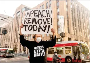  ?? The Associated Press ?? Kenneth Lundgreen holds a sign against President Donald Trump outside Twitter on Monday in San Francisco.