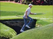  ?? CURTIS COMPTON/CURTIS.COMPTON@AJC.COM ?? Jordan Spieth runs across the tributary to Rae’s Creek to the 13th green during his practice round for the Masters at Augusta National Golf Club on Tuesday. Rae’s Creek winds through Augusta National at Amen Corner, the famous stretch of holes often instrument­al in deciding the Masters winner.