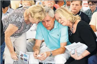  ?? PATRICK SEMANSKY/THE ASSOCIATED PRESS ?? Carl Hiaasen (centre) brother of Rob Hiaasen, one of the journalist­s killed in the shooting at The Capital Gazette newspaper offices, is consoled by his sisters Barb, (left) and Judy during a memorial service July 2 in Owings Mills, Md.