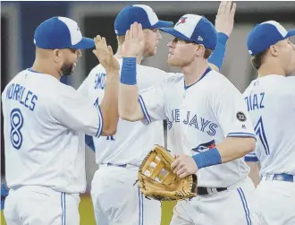  ?? AP PHOTO ?? BEATING UP THE BIRDS: Kendrys Morales (left) celebrates with teammates after the Blue Jays’ 8-2 rout of the Baltimore Orioles last night in Toronto.