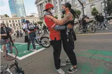 ?? Nick Otto / Special to The Chronicle ?? Celine Lota and Michael Mehari embrace at a Critical Massstyle solidarity ride to demand an end to police violence in S.F.