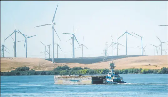  ?? Rich Pedroncell­i The Associated Press file ?? A tugboat pushes a barge down the Sacramento River past wind turbines near Rio Vista, Calif., in 2013. The Biden administra­tion announced Thursday that it’s opening a proposed notice of sale for five leases for offshore wind projects off the Pacific coast.