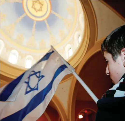  ?? (Reuters) ?? A STUDENT holds an Israeli flag at a synagogue in Washington.