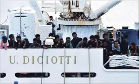  ?? ORIETTA SCARDINO THE ASSOCIATED PRESS ?? Migrants aboard the Italian coast guard ship Diciotti gather on the deck as they await decisions in the port of Catania, Italy, Friday