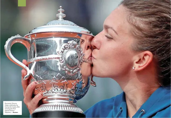  ?? — Reuters ?? Romania’s Simona Halep celebrates by kissing the trophy after winning the final against Sloane Stephens.