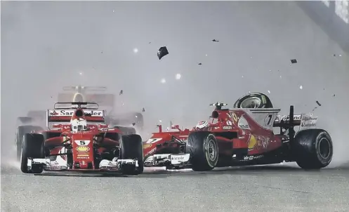  ??  ?? 0 Sebastian Vettel, left, and Kimi Raikkonen collide during the first lap of the race, leaving the door open for Lewis Hamilton to win.